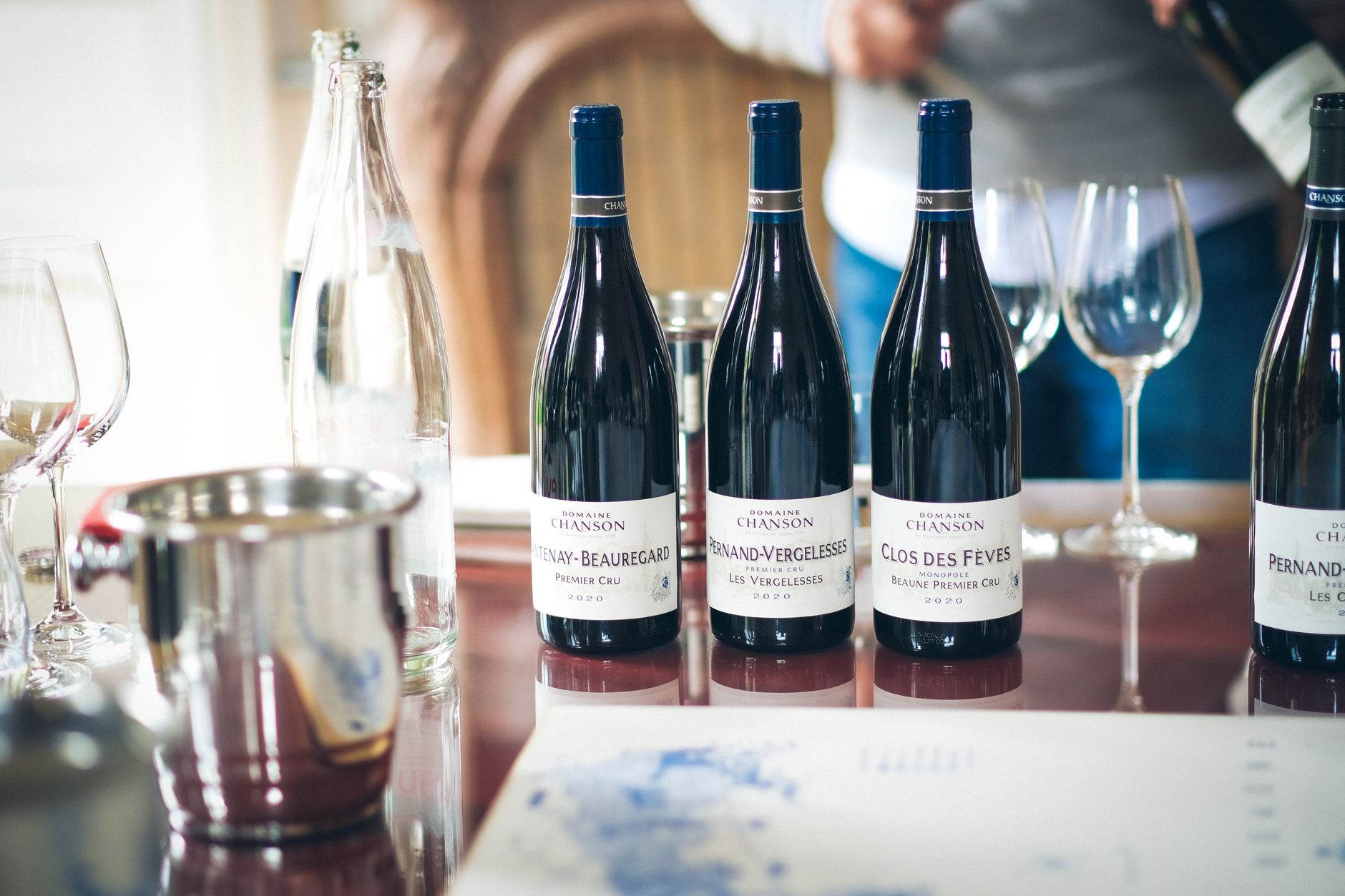Elegant wine tasting setup in Beaune, featuring French wine bottles and glasses on a table.