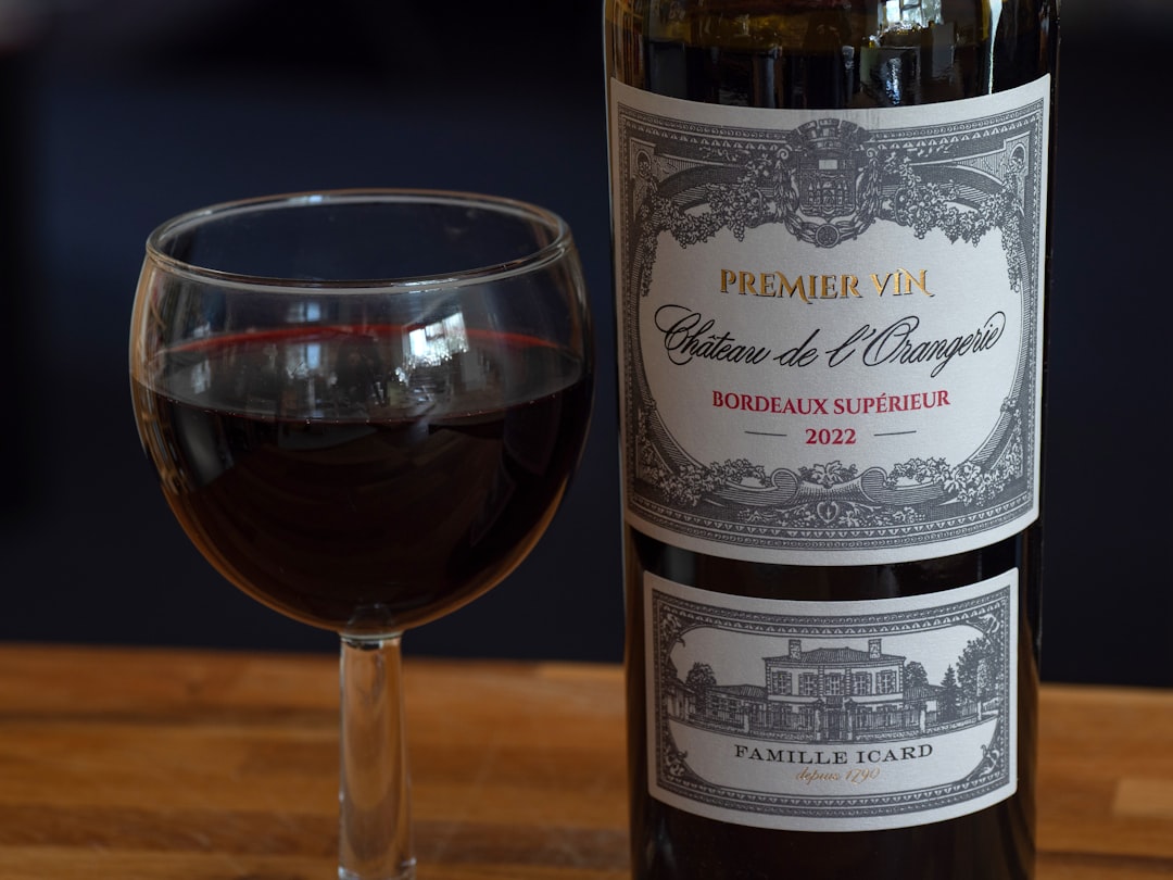 A glass of red wine next to a bottle