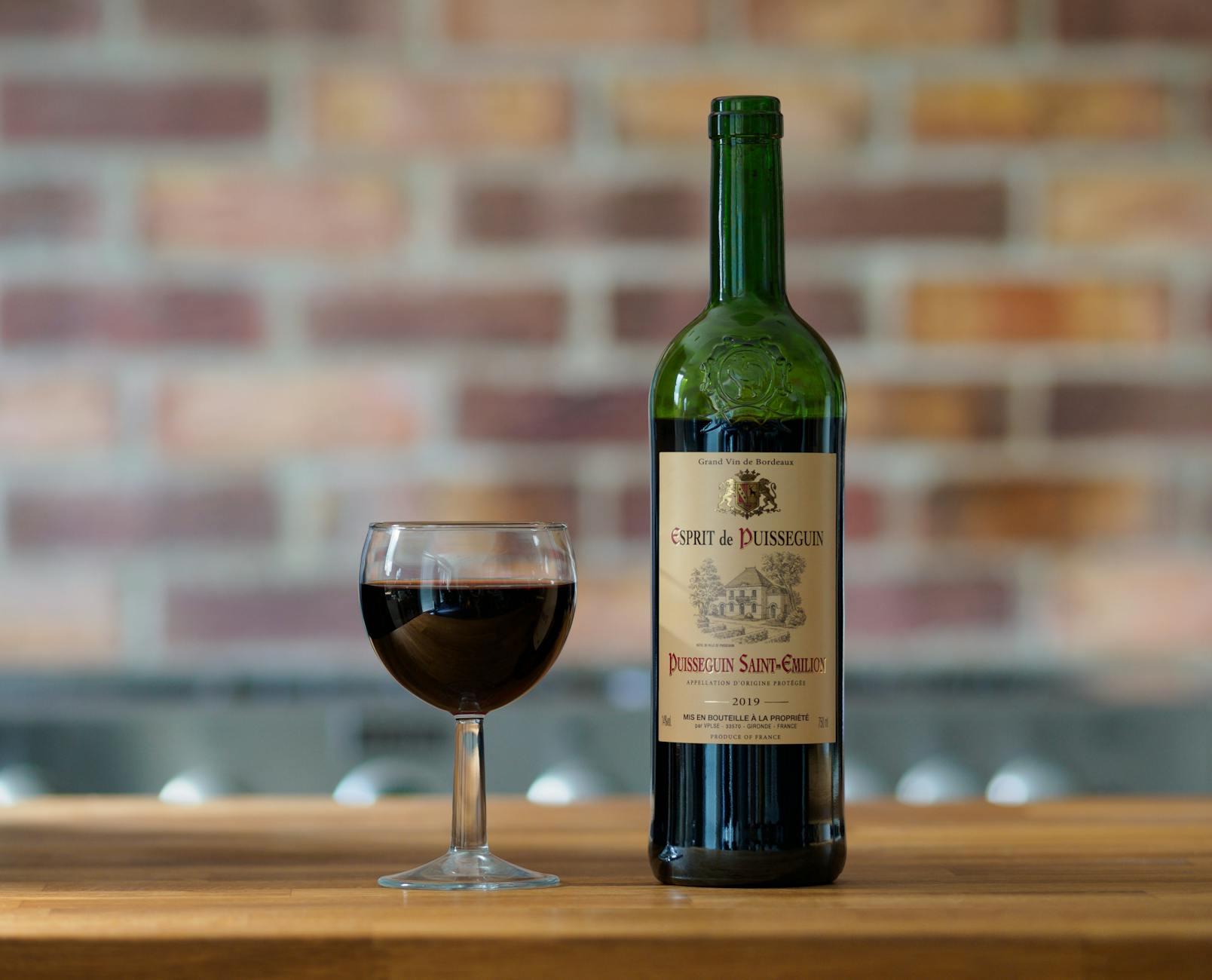 Elegant French red wine with goblet on wooden table, perfect for gourmet dining.