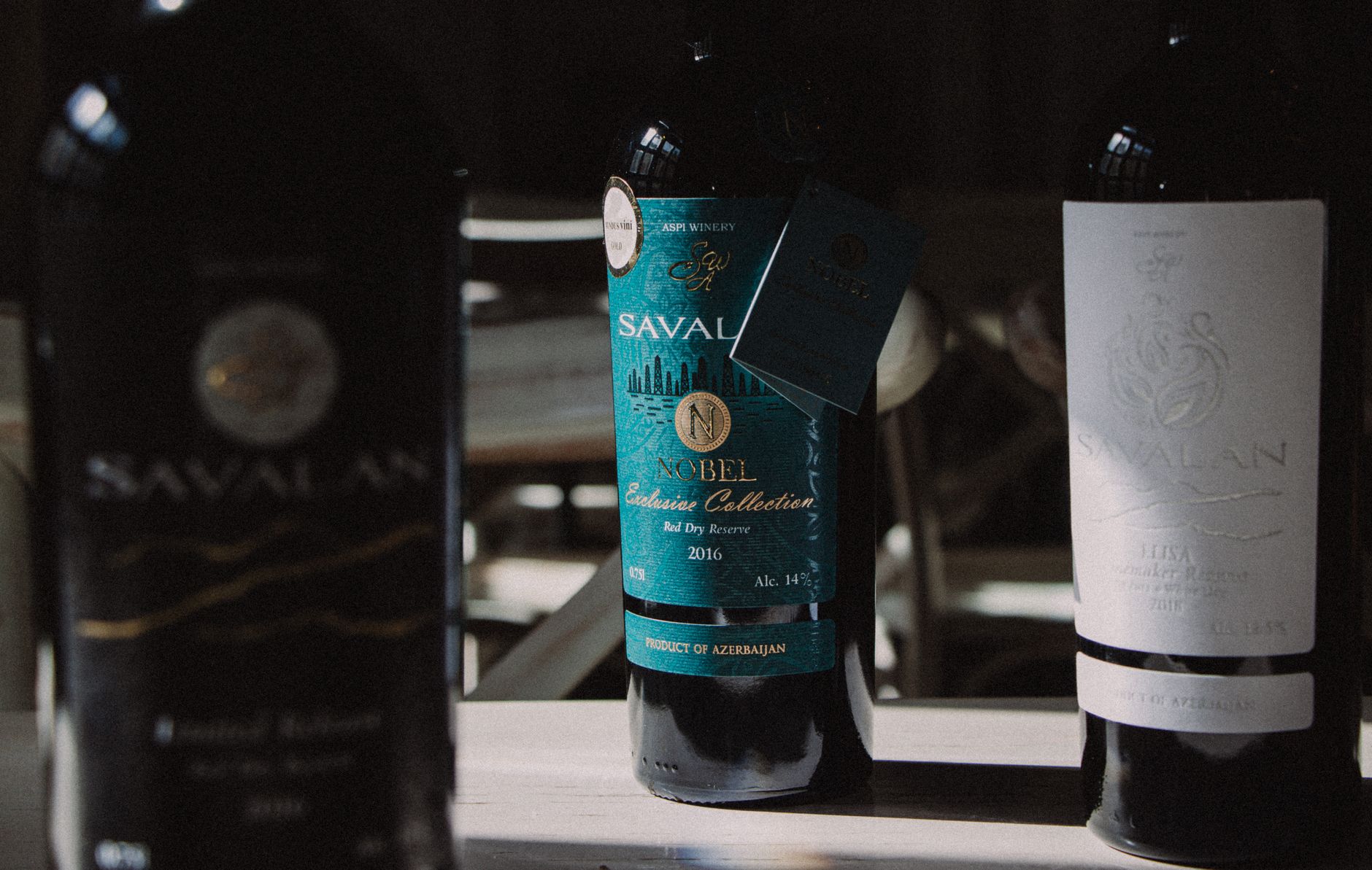 Three Savalan wine bottles arranged on a table, showcasing labels and brand.