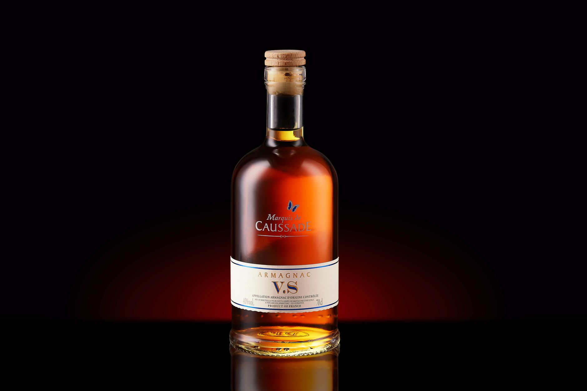 A bottle of Armagnac VS with a cork, elegantly displayed against a dark background.