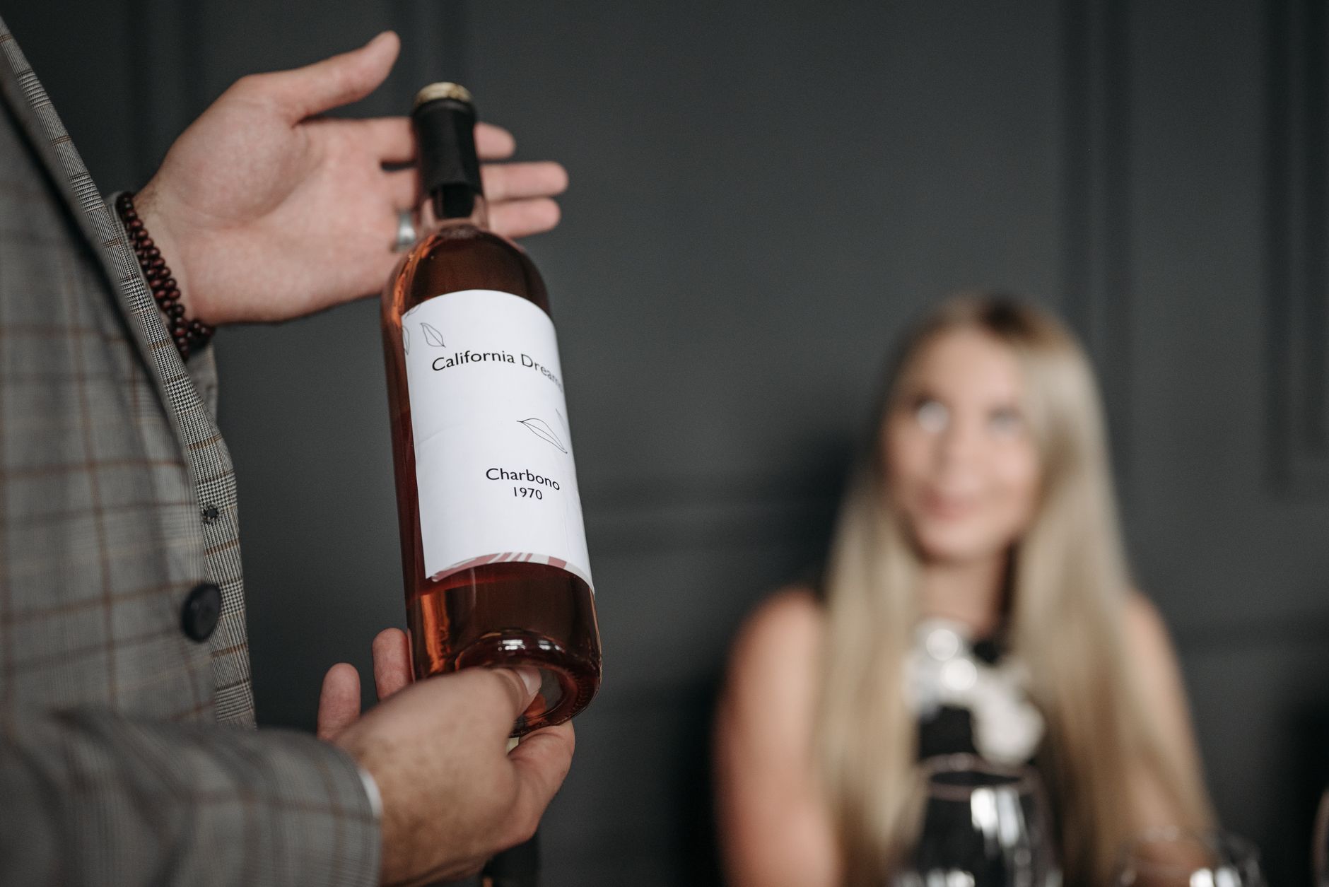 Gentleman presenting California Dream wine at an elegant indoor tasting event.