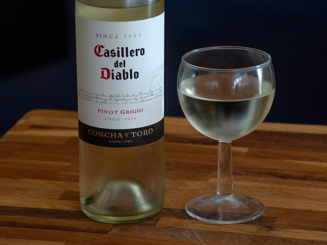 Bottle and glass of white wine on table