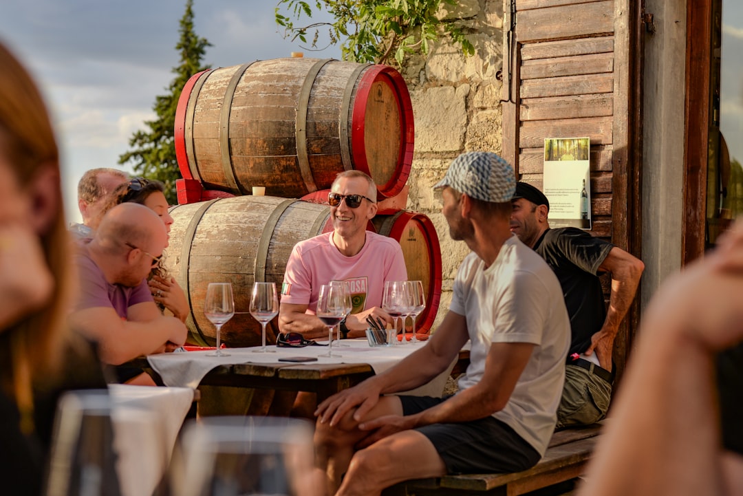 People enjoying wine tasting at a winery with barrels